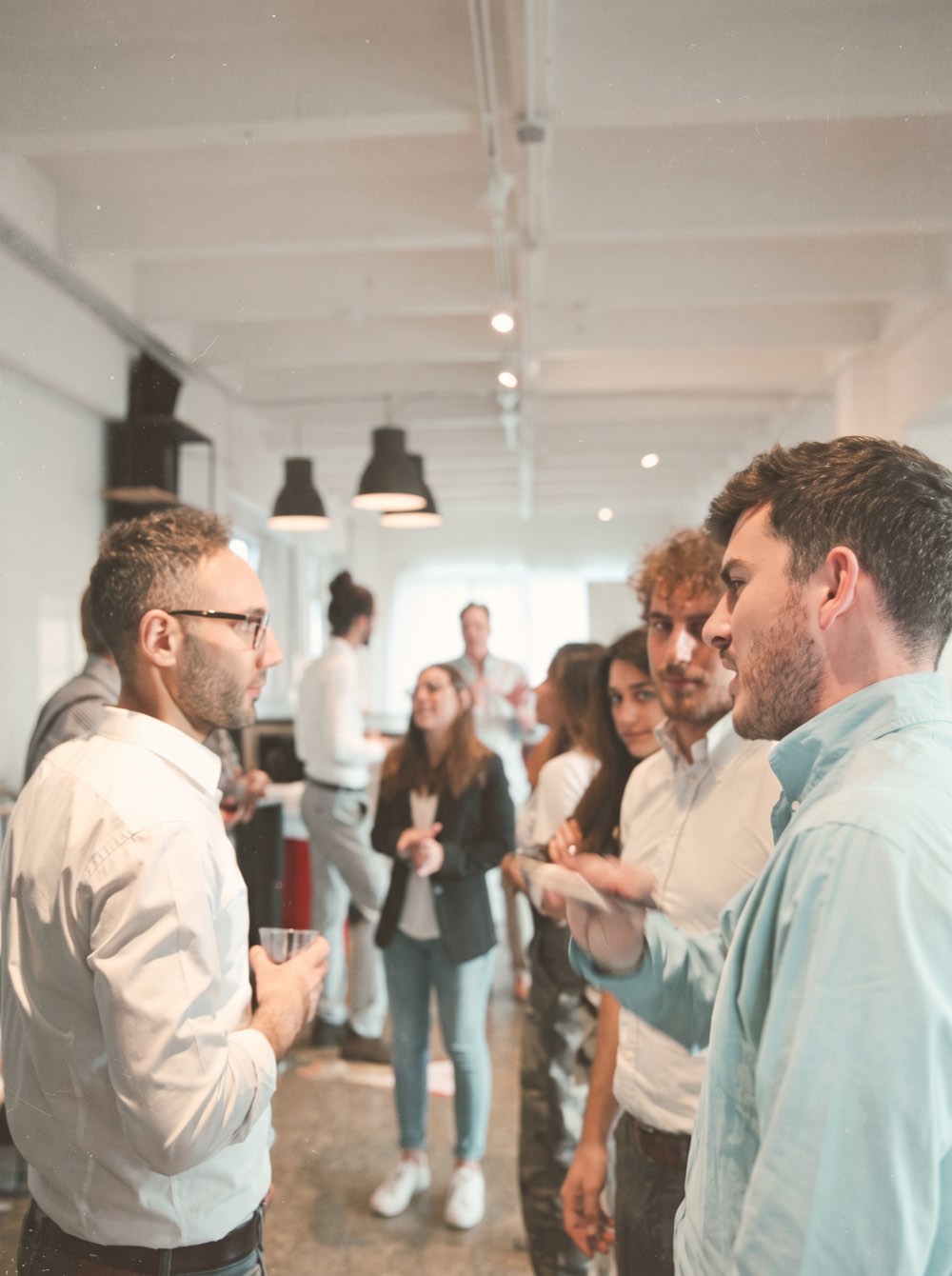 A group of people talking in a bright office space